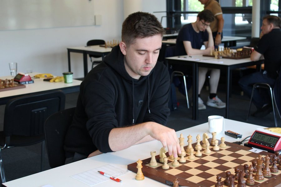 Jakob Pajeken at a chess tournament, making a move on the board